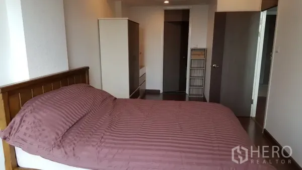 Condominium for rent in Sathon, Bangkok - Bedroom with wooden bed, wardrobe, dresser and wood flooring.