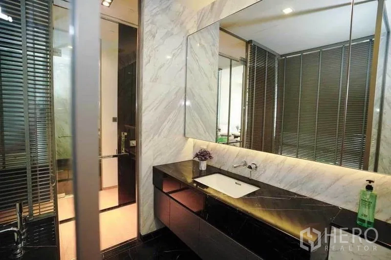 公寓 出租在Bang Rak, Bangkok - 浴室内大镜面与氛围灯的大理石台盆柜。