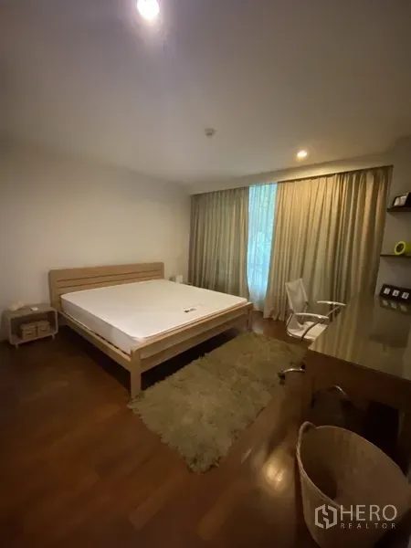 คอนโด ให้เช่าหรือขายในKhlong Toei, Bangkok - ห้องนอนกว้าง เตียงขนาดใหญ่ โต๊ะทำงานและเก้าอี้ พรมปูพื้นไม้ และหน้าต่างบานกว้างพร้อมผ้าม่าน