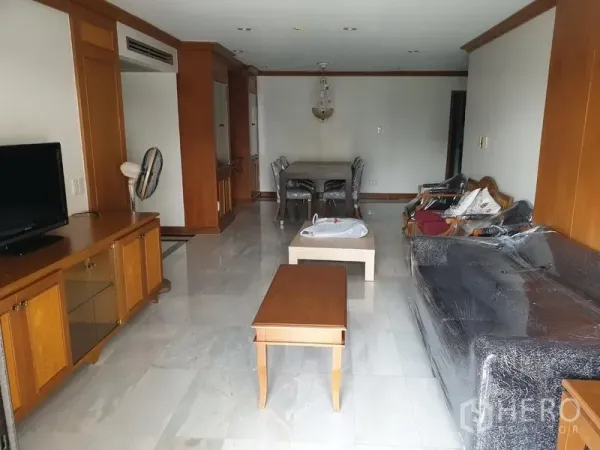 Condominium for rent in Watthana, Bangkok - Wide living area with sofa set, TV console and coffee tables leading to the dining zone.