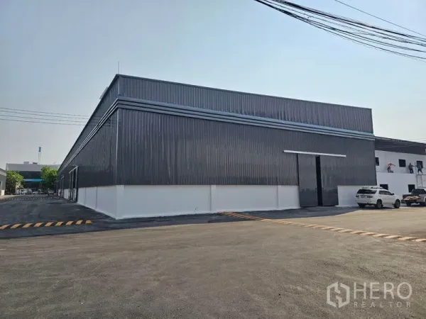 货栈 出租在Khlong Toei, Bangkok - 金属板仓库外角，设大型推拉门与停车区域。