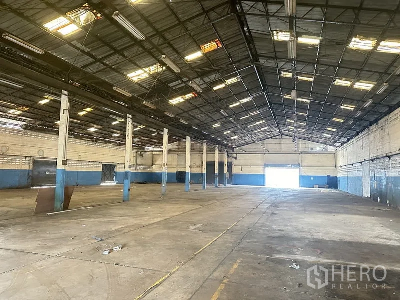 โรงงาน ขายในKhlong Luang, Pathum Thani - ฮอลล์โกดังกว้าง มีเสากลางหลายต้นและประตูโหลดด้านไกล