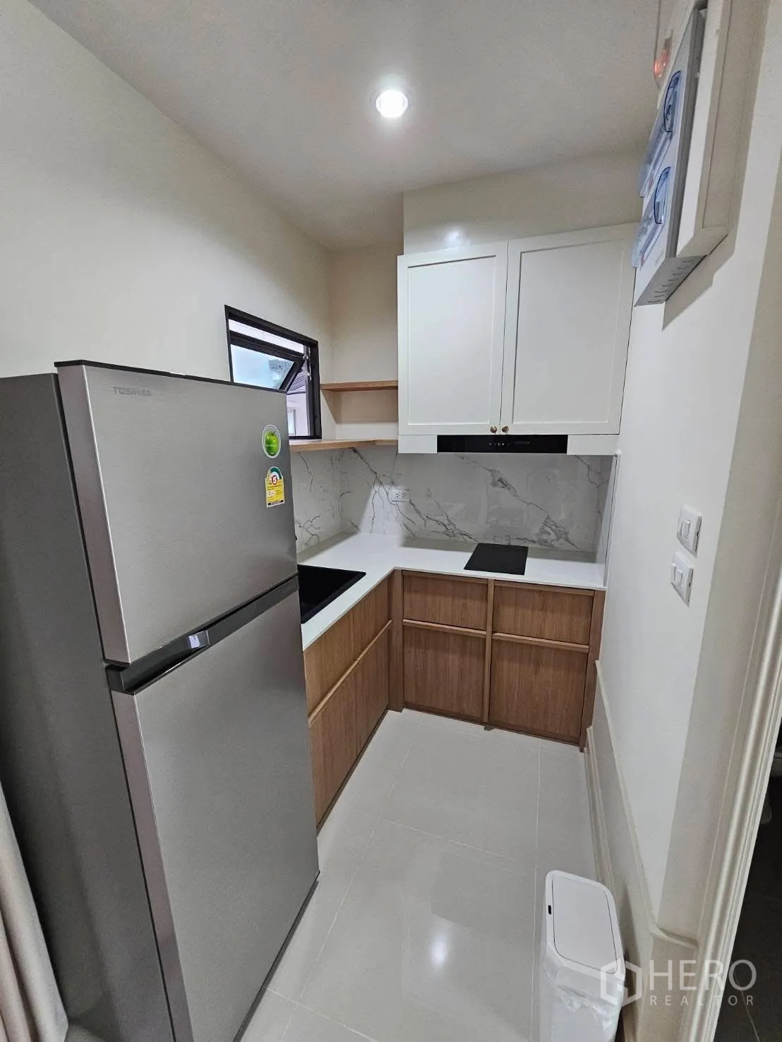 ทาวน์เฮาส์ for rent in Saphan Sung, Bangkok - ครัวรูปตัวแอล ตู้บิวท์อินสีขาวและไม้ ผนังลายหินอ่อน เตาอินดักชัน และตู้เย็นสแตนเลส