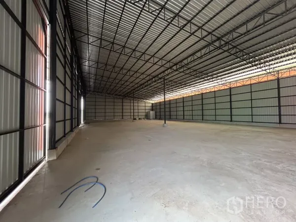 Warehouse for rent in Khlong Toei, Bangkok - Spacious warehouse interior with high steel truss roof and smooth concrete floor for storage and logistics.