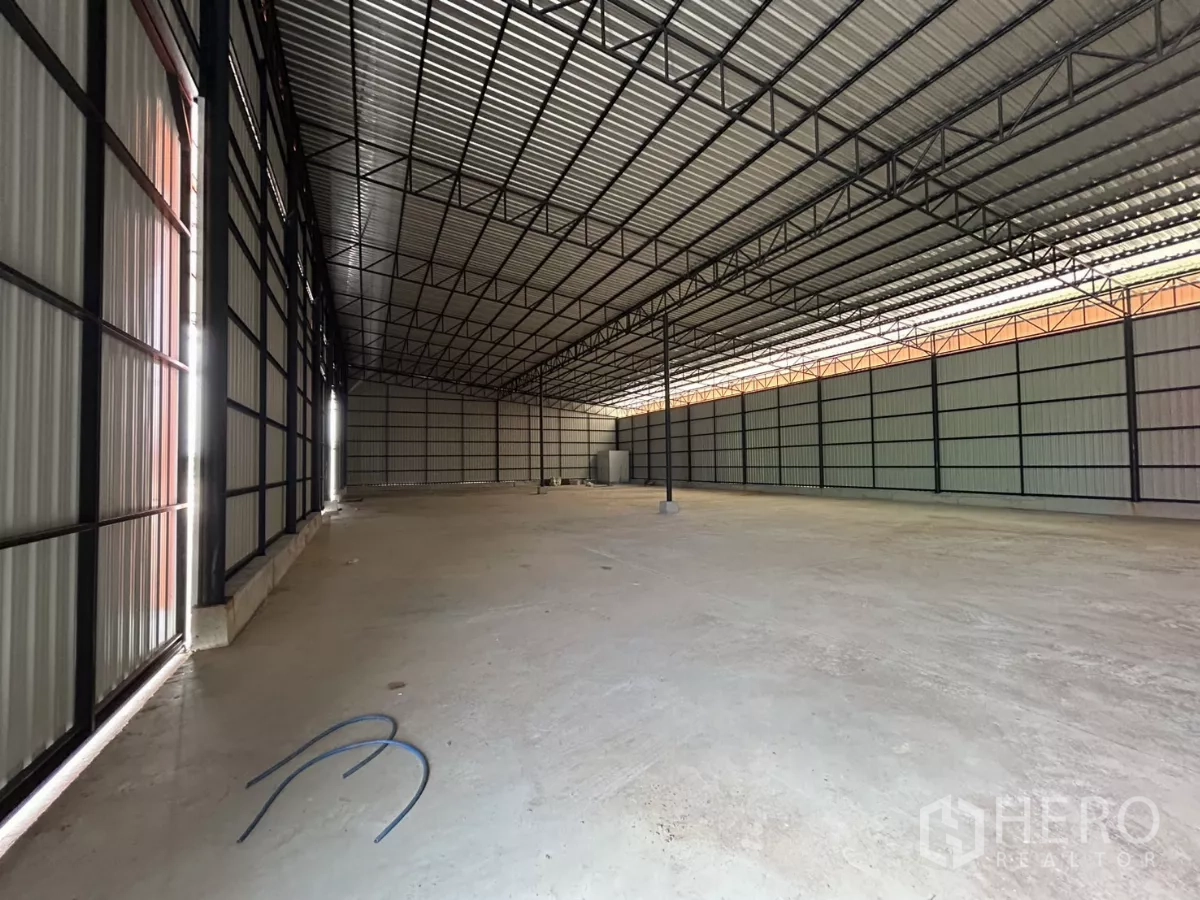 Warehouse for rent in Khlong Toei, Bangkok - Spacious warehouse interior with high steel truss roof and smooth concrete floor for storage and logistics.