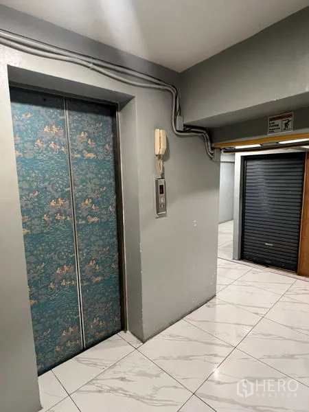 พื้นที่ขายปลีก ให้เช่าในKhlong Toei, Bangkok - โถงลิฟต์ ประตูลิฟต์ลายลวดลาย พื้นกระเบื้อง และประตูม้วนใกล้เคียง.