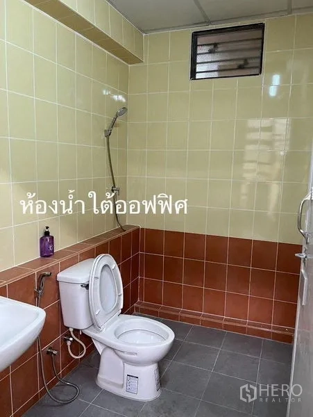 Warehouse for rent in Lam Luk Ka, Pathum Thani - Tiled bathroom with toilet, sink and shower inside the warehouse office.