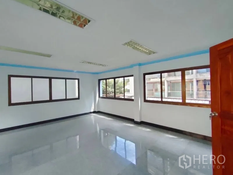 带办公室的家 出租在Pathum Wan, Bangkok - 转角办公空间，配多扇窗与荧光顶灯。