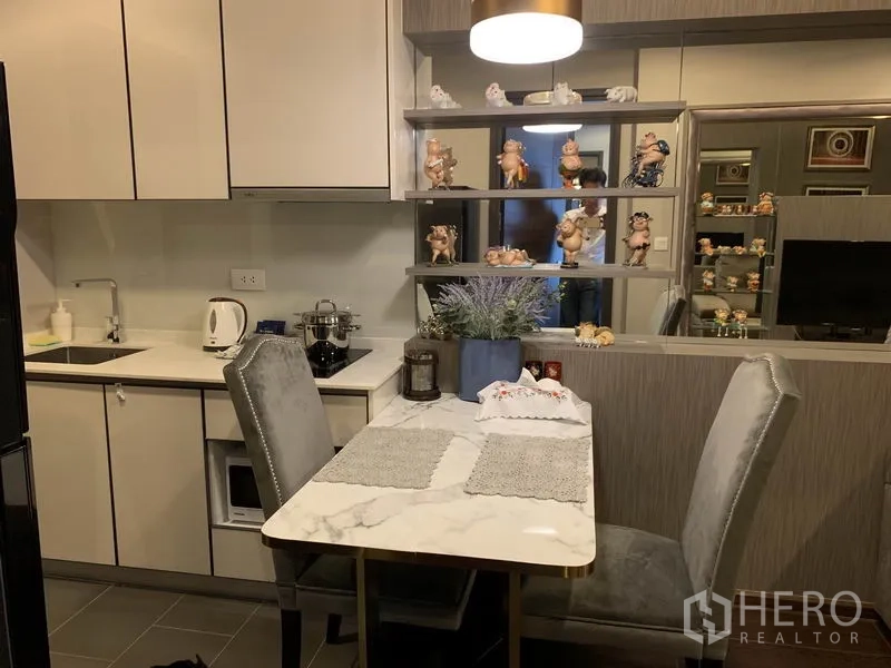 公寓 出售在Watthana, Bangkok - 曼谷公寓紧凑型厨房，白色橱柜与大理石餐桌，开放式陈列架，临近Ekkamai。