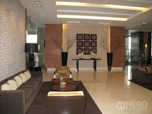 คอนโด ให้เช่าในSathon, Bangkok - ล็อบบี้คอนโดสมัยใหม่ มีชุดโซฟา แสงไฟตกแต่ง และงานศิลป์ผนัง.