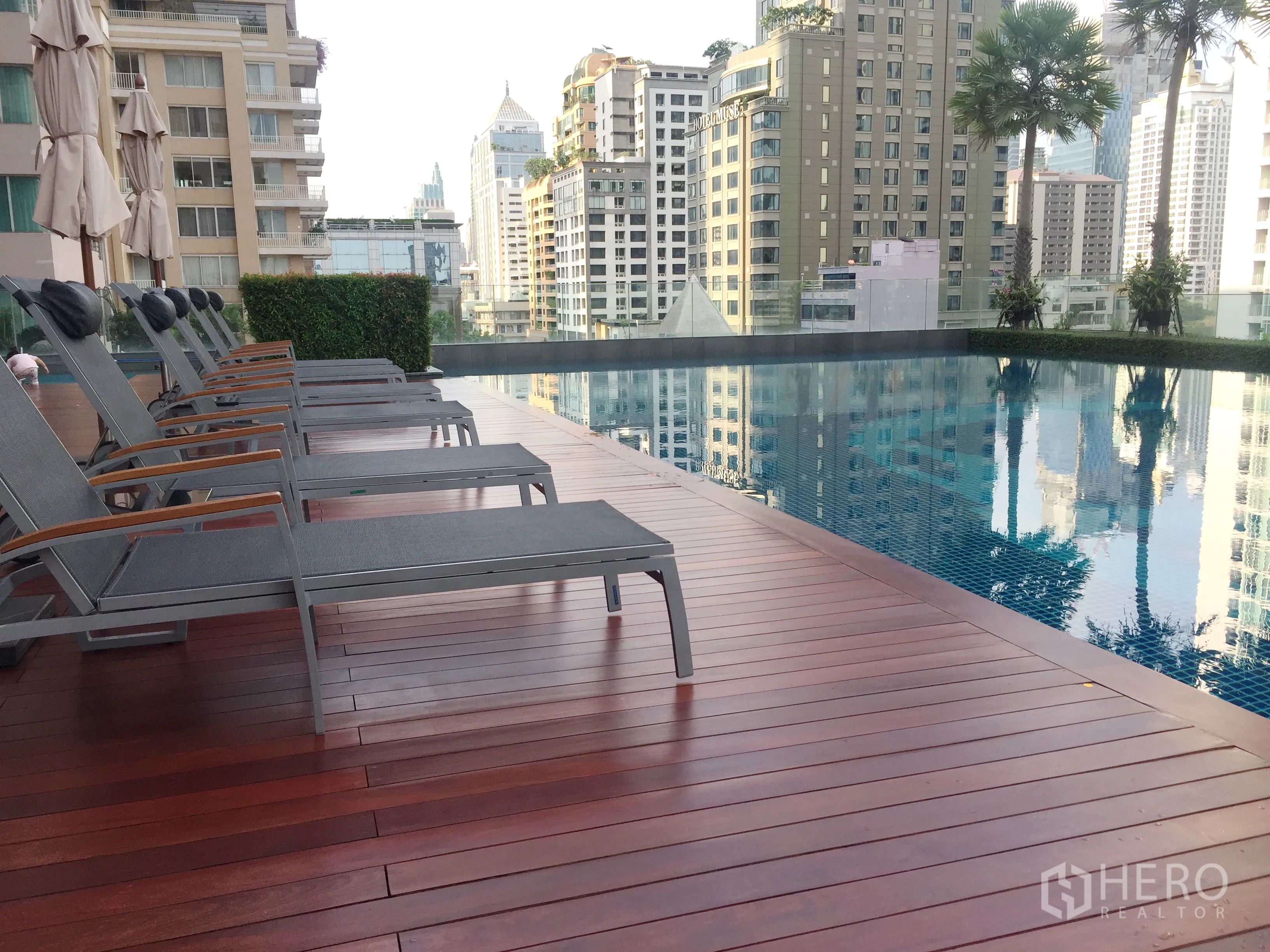 Condominium for rent in Pathum Wan, Bangkok - Rooftop-style swimming pool with sun loungers and city skyline views.