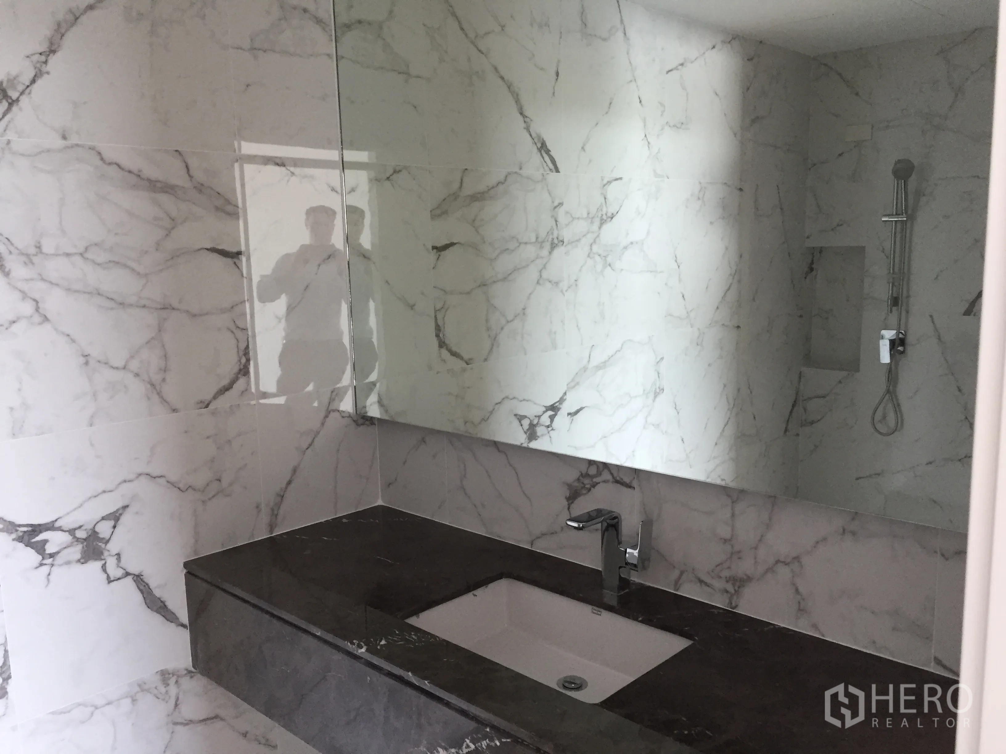 Townhouse for rent in Saphan Sung, Bangkok - Secondary bathroom with marble walls, long stone vanity and walk-in shower.
