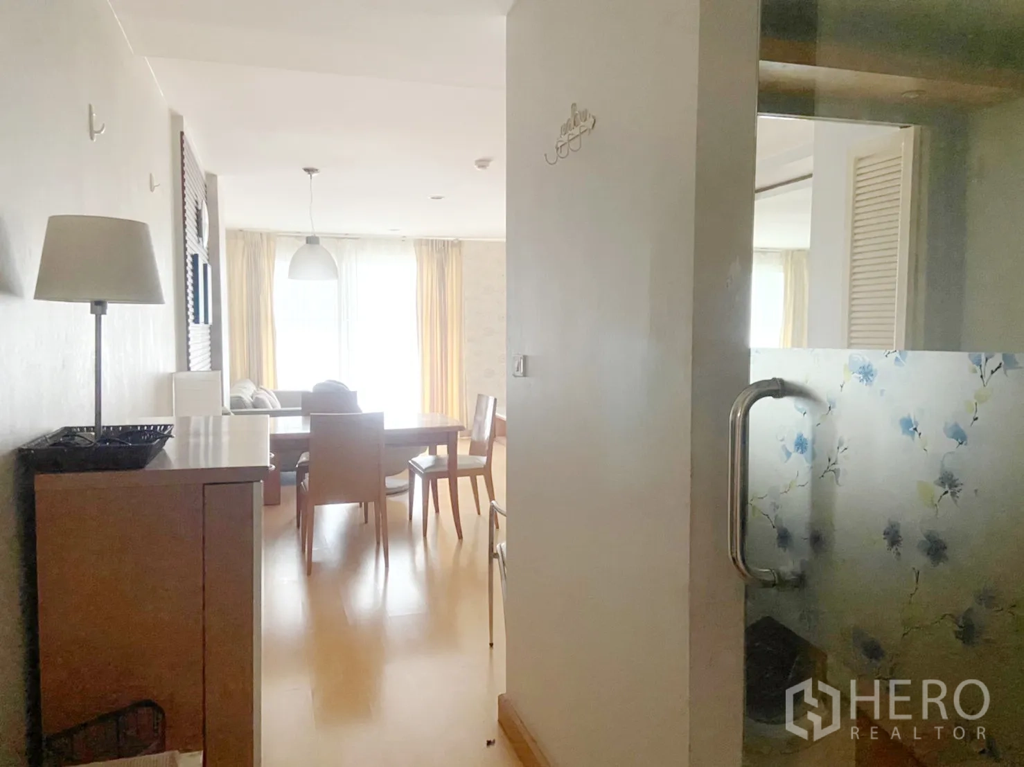 คอนโด ให้เช่าในWatthana, Bangkok - มุมโถงทางเดินมองไปยังโต๊ะกินข้าวและห้องนั่งเล่น พร้อมประตูกระจกฝ้าลายดอก
