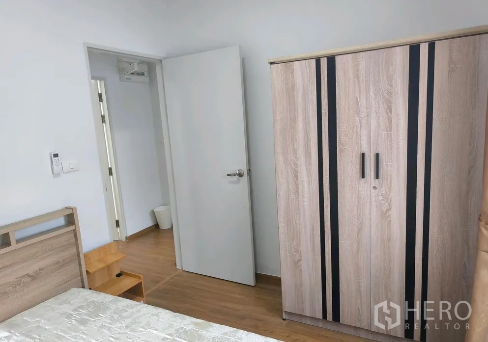 Townhouse for rent in Bang Phli, Samut Prakan - Bedroom wardrobe with wood grain finish beside matching furniture.