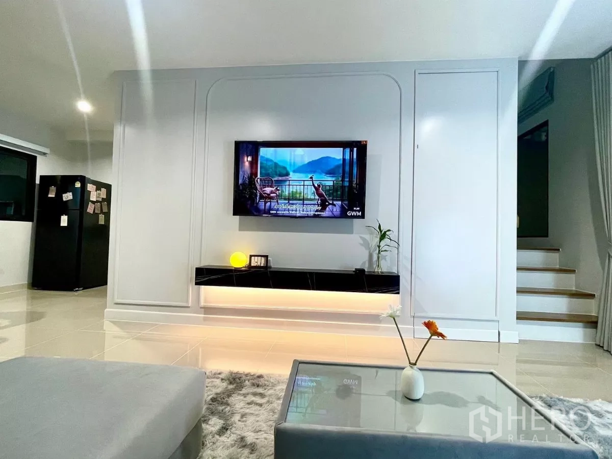 ทาวน์เฮาส์ ให้เช่าในSamut Prakan - ห้องนั่งเล่นสว่าง ผนังทีวีบิวท์อิน ชั้นวางลอย และบันได