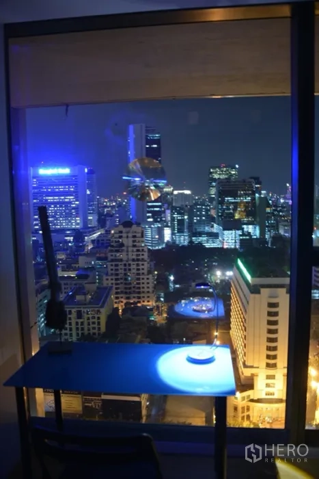 公寓 出租或出售在Sathon, Bangkok - 窗边书桌，俯看曼谷夜色。