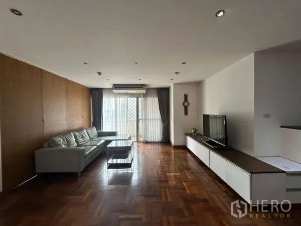 Condominium for rent in Watthana, Bangkok - Wide living room showing sofa, TV console and balcony access.