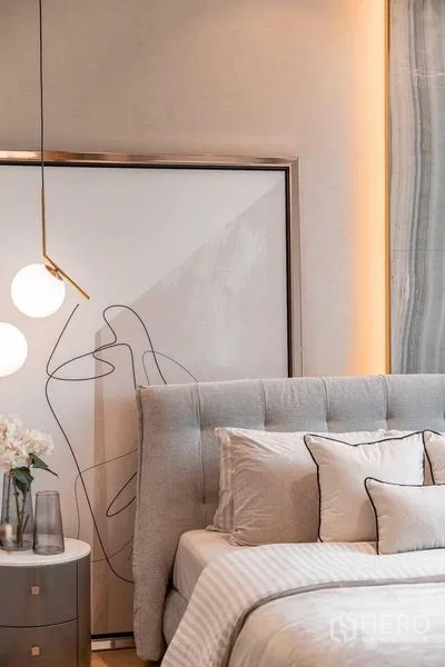 Condominium for rent or sale in Pathum Wan, Bangkok - Bedroom corner with tufted headboard, abstract artwork and pendant pendant lights.