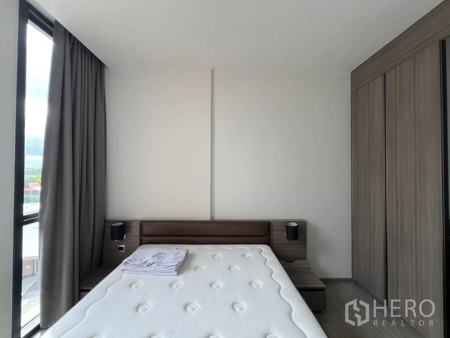 公寓 for rent in Watthana, Bangkok - 卧室配大床、床头柜与窗边的内置衣柜。