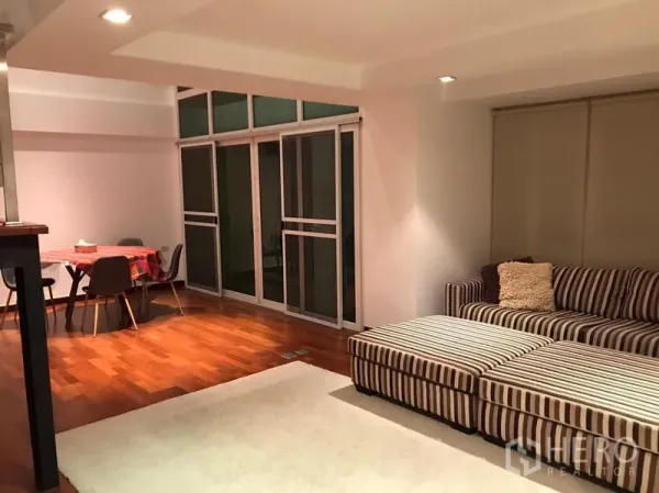 คอนโด ให้เช่าในWatthana, Bangkok - พื้นที่นั่งเล่นและรับประทานอาหารแบบเปิดโล่ง พร้อมประตูกระจกบานเลื่อนและพื้นไม้