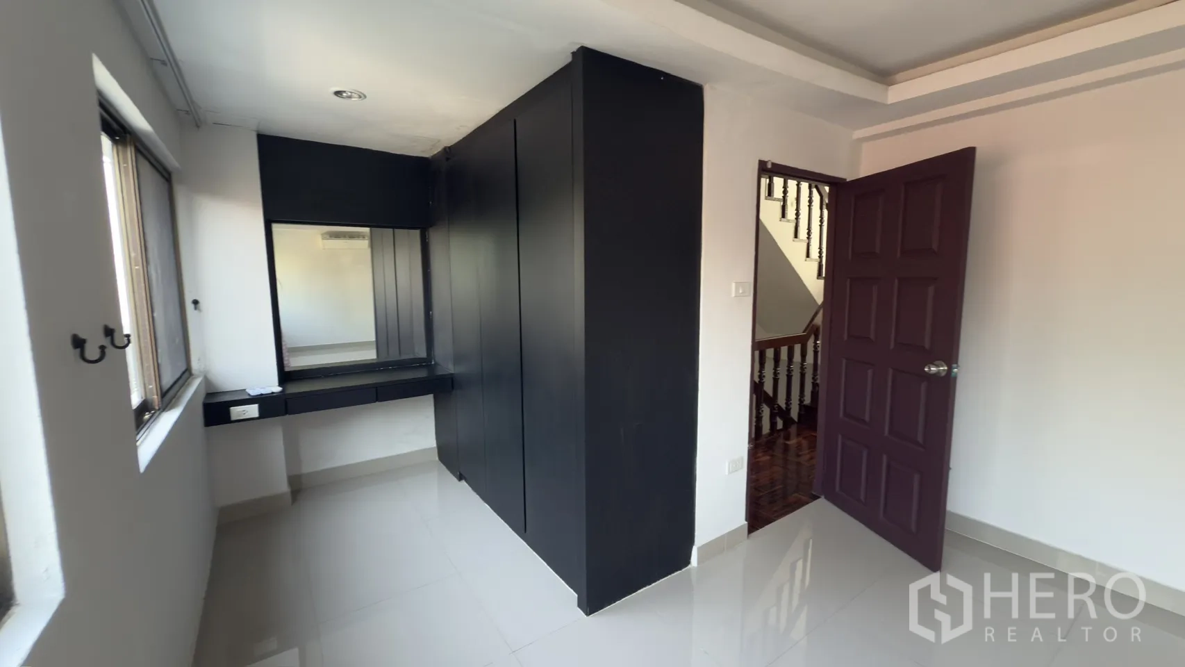 ทาวน์เฮาส์ for rent in Watthana, Bangkok - ห้องสว่างพื้นกระเบื้องเงา มีตู้เสื้อผ้าสีดำบิวท์อินและโต๊ะเครื่องแป้ง ใกล้บันได