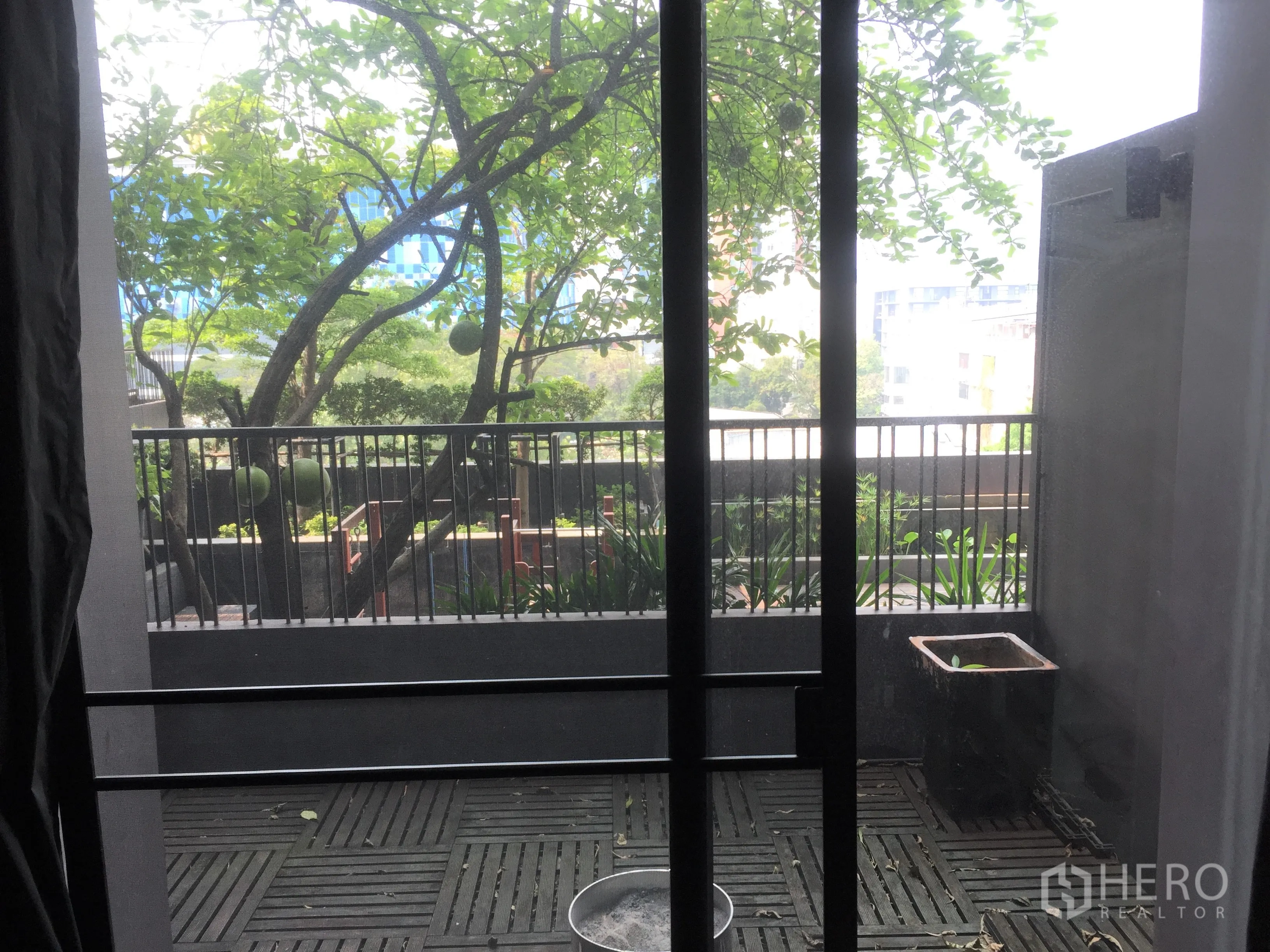 คอนโด ให้เช่าหรือขายในWatthana, Bangkok - ระเบียงส่วนตัวปูพื้นไม้ มองเห็นวิวสวนร่มรื่นและทิวทัศน์เมืองบางส่วน