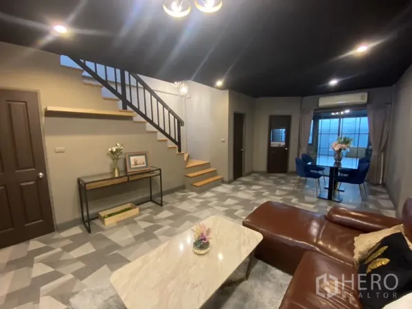 Townhouse for rent in Bang Kapi, Bangkok - View of staircase, spacious living zone and dining corner under modern lighting.