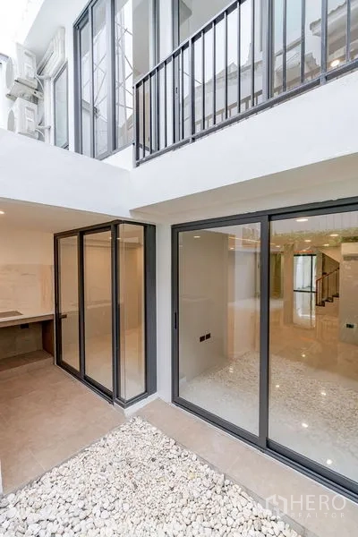 Townhouse for sale - Internal courtyard with sliding glass doors and white pebble ground.