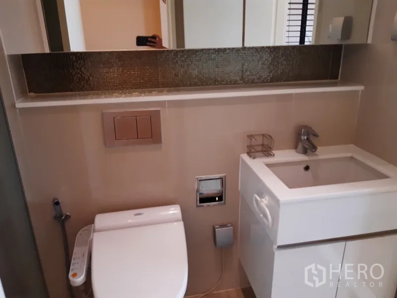 คอนโด ให้เช่าในWatthana, Bangkok - ห้องน้ำสมัยใหม่มีอ่างล้างหน้า กระจกเงาบานยาว และโถสุขภัณฑ์พร้อมสายฉีด