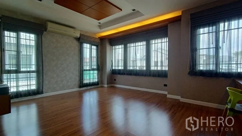 独立式住宅 出售在Prawet, Bangkok - 转角主卧，多个窗户、木地板与嵌入式灯带天花。