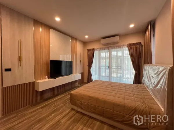 บ้าน ให้เช่าในBang Kapi, Bangkok - มุมอื่นของห้องนอนใหญ่ เห็นเตียงคิงไซส์ ผนังทีวี และเครื่องปรับอากาศ