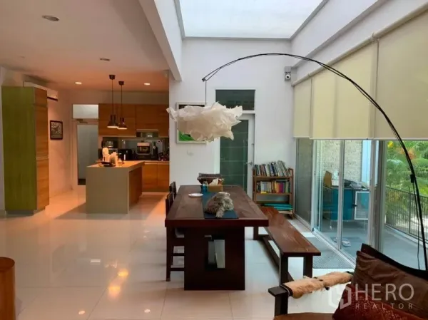 บ้าน ขายในSuan Luang, Bangkok - พื้นที่รับประทานอาหารและครัวแบบเปิดโล่งสว่างด้วยสกายไลท์ โต๊ะไม้ยาว ไอส์แลนด์ และหน้าต่างสูงจรดเพดาน