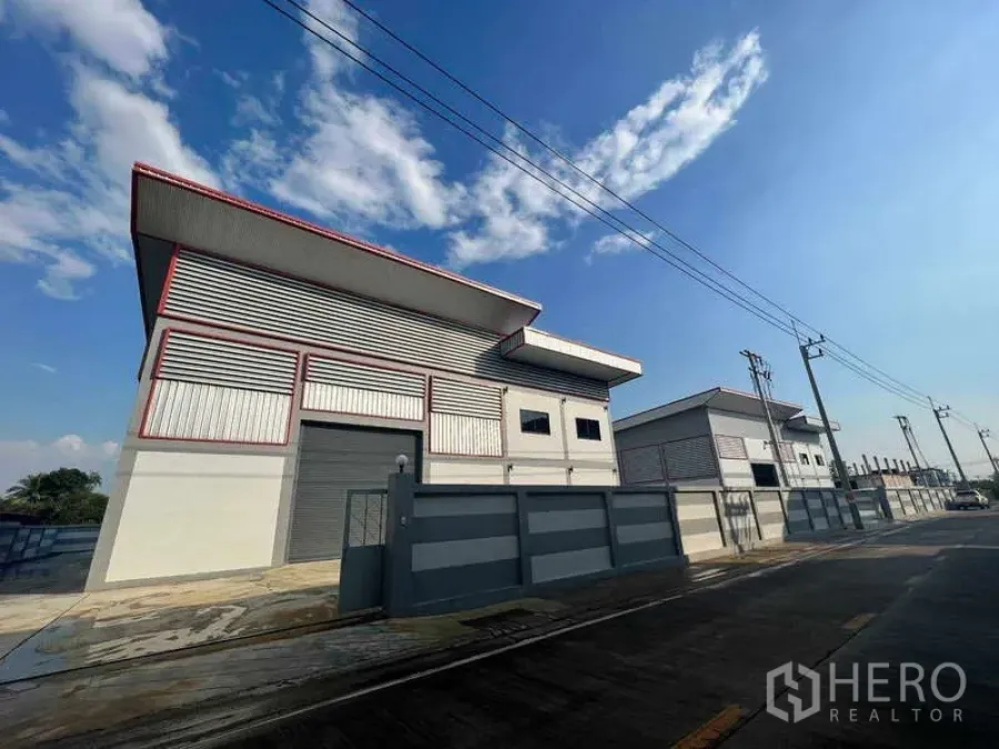 Warehouse for rent or sale in Krathum Baen, Samut Sakhon - Street-side view of the warehouse facade with roller doors and a secure perimeter gate.