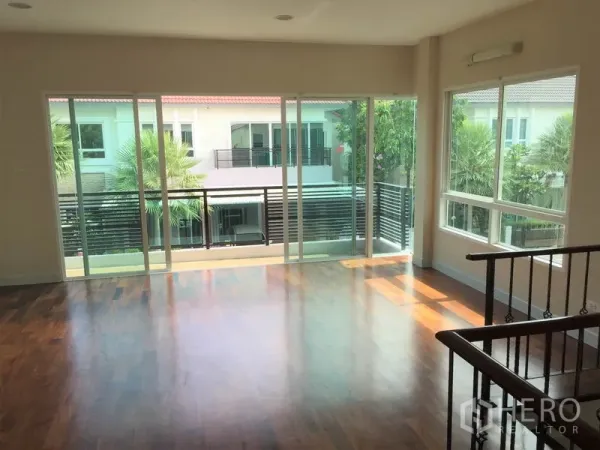 Detached House for rent in Saphan Sung, Bangkok - Upstairs family room with wood floors and wide sliding doors opening to a long balcony.