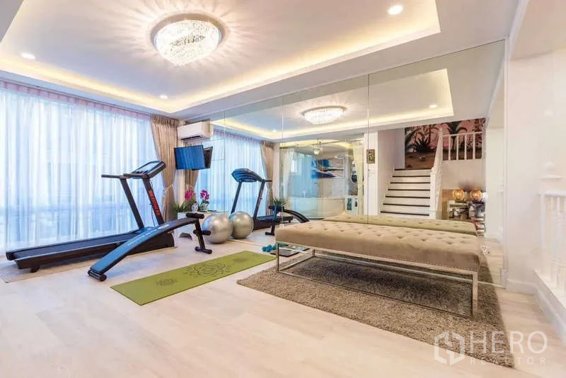 联排别墅 出租在Lat Phrao, Bangkok - 家庭健身房，配跑步机、整面镜墙、大窗与嵌灯天花。