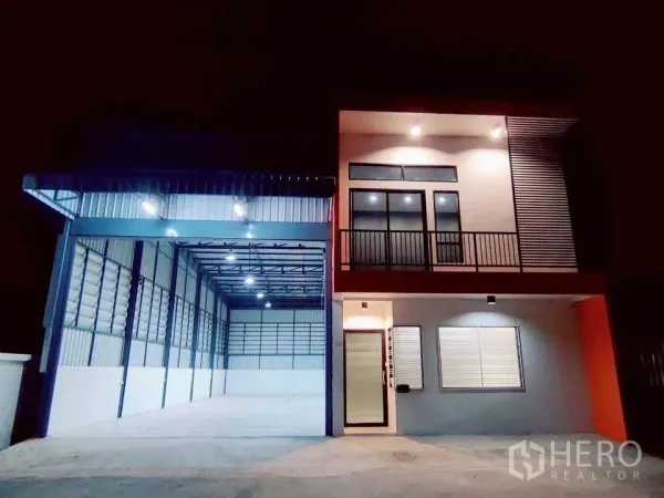 Warehouse for rent in Lam Luk Ka, Pathum Thani - Modern two-storey warehouse with lit loading bay and balcony at night in Lam Luk Ka.