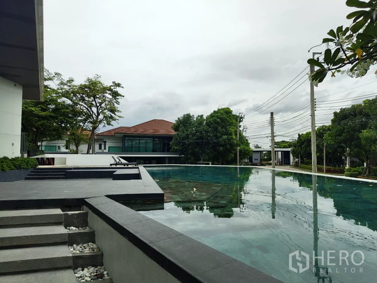 Detached House for sale in Bang Kapi, Bangkok - Large saltwater swimming pool by the clubhouse with sun loungers.