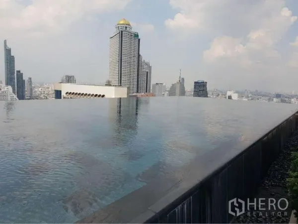 Condominium for rent in Sathon, Bangkok - Rooftop infinity pool with city view and tall buildings on the horizon.