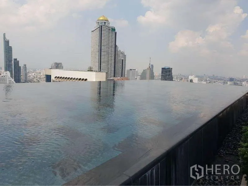 Condominium for rent in Sathon, Bangkok - Rooftop infinity pool with city view and tall buildings on the horizon.