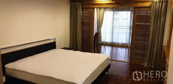 อพาร์ทเมนท์ ให้เช่าในWatthana, Bangkok - ห้องนอนกว้าง พื้นไม้ขัดเงา ประตูบานเกล็ด มุมโต๊ะทำงาน และทางออกสู่ระเบียงผ่านผ้าม่านโปร่ง