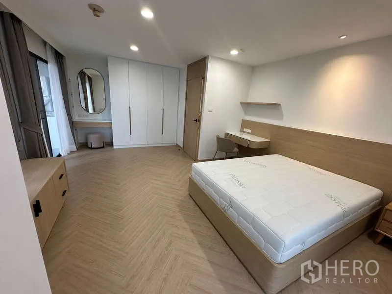 คอนโด ให้เช่าในWatthana, Bangkok - ห้องนอนสำหรับแขกพร้อมตู้เสื้อผ้าบิวท์อิน โต๊ะเครื่องแป้ง และทางออกระเบียง