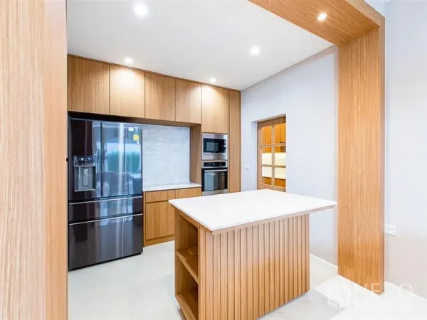 独立式住宅 出租或出售在Prawet, Bangkok - 现代厨房，木质橱柜、中央岛台与双开门冰箱