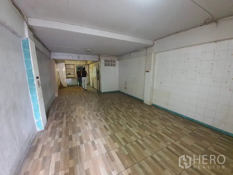 Shophouse for rent in Bang Rak, Bangkok - Ground-floor shophouse interior with wood-look tiles and white walls, open space for retail or showroom.