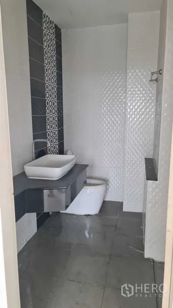 联排别墅 for 在Lam Luk Ka, Pathum Thani - 现代浴室，台上盆、坐便器与灰色地砖。