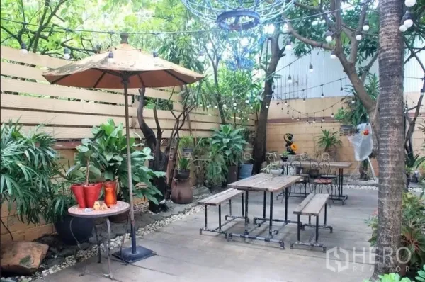 บ้าน ให้เช่าในWatthana, Bangkok - พื้นที่นั่งเล่นกลางแจ้งเขียวร่ม มีม้านั่ง ร่มสนาม และไฟประดับบนลานปูพื้น