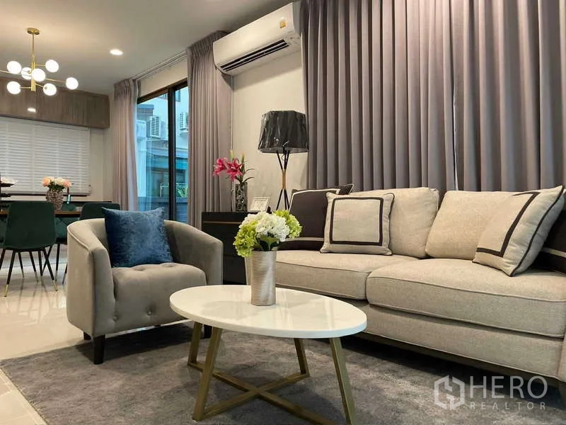 Detached House for rent in Bang Kapi, Bangkok - Bright living and dining area with sofa set, coffee table and sliding glass doors in Burasiri Krungthep Kreetha, Bang Kapi.