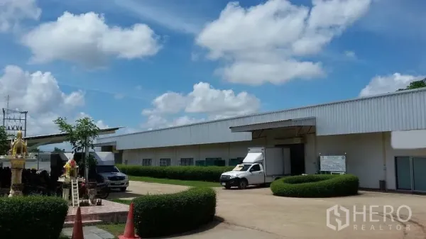 Warehouse for rent in Nakhon Ratchasima - Loading bay with roll-up door, truck parking area and neatly trimmed hedges at the warehouse.