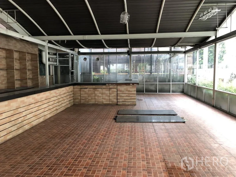 零售空间 出租在Khlong Toei, Bangkok - 带顶露台零售区，砖色地砖、长服务台与玻璃围墙，采光充足