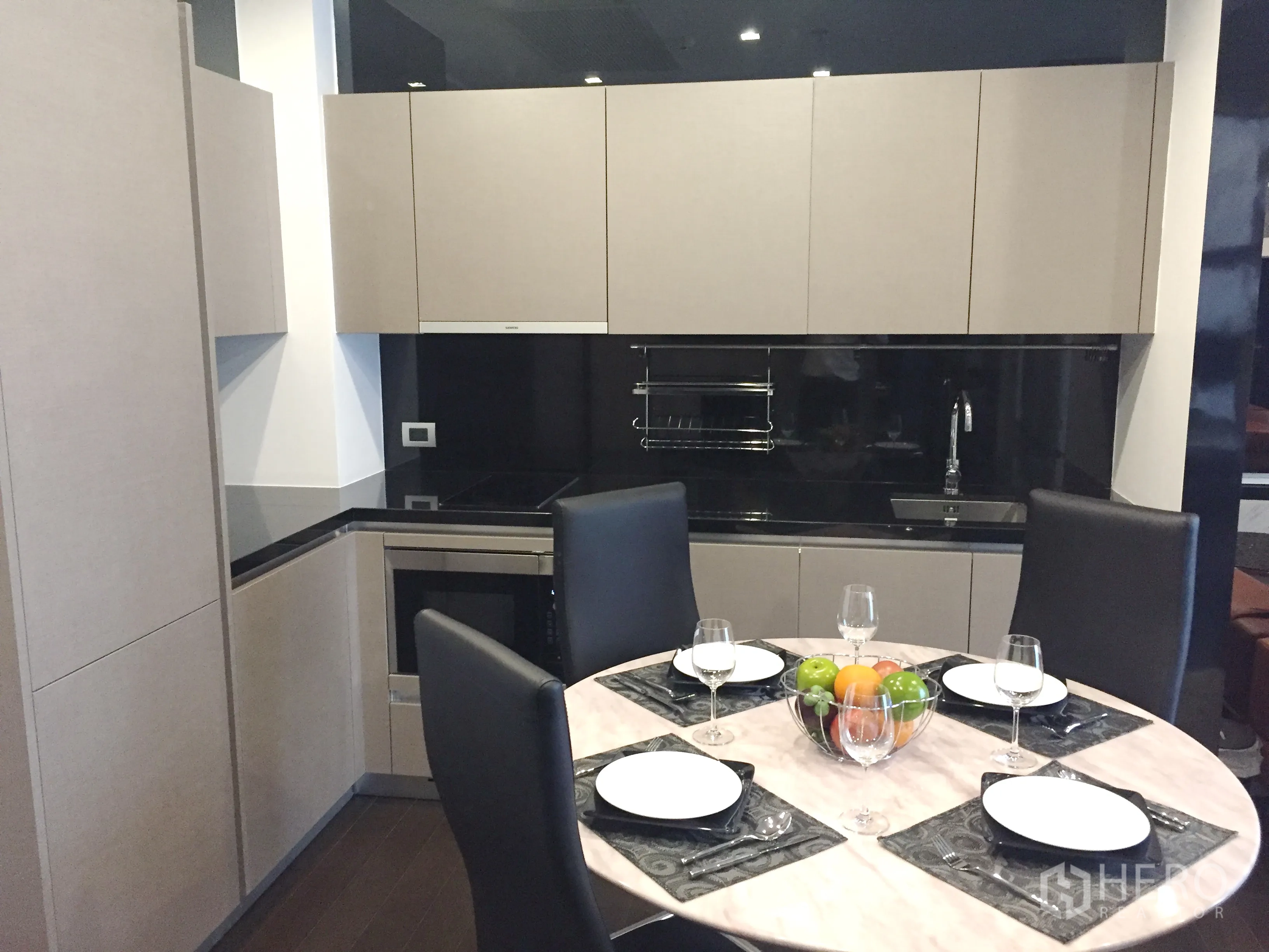 คอนโด ให้เช่าในWatthana, Bangkok - ครัวบิวต์อินรูปตัวแอล ท็อปหินสีดำ เครื่องใช้ครบ พร้อมโต๊ะอาหารทรงกลม