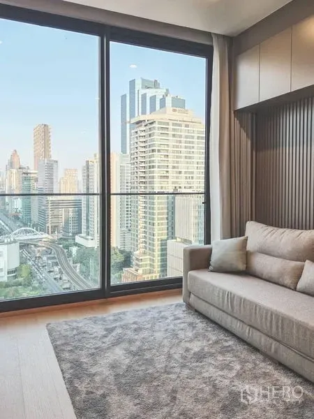 Condominium for rent in Bang Rak, Bangkok - Sofa by large sliding glass doors with expansive high-rise city views.